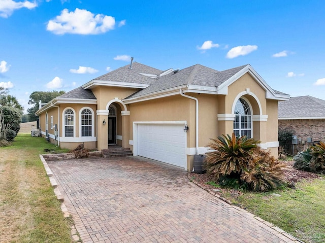 view of front of house with a garage, a shingled roof, decorative driveway, and stucco siding