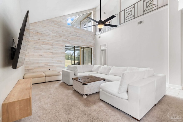 carpeted living area with lofted ceiling, ceiling fan, and visible vents