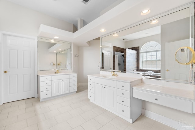 full bath featuring a shower stall, two vanities, a sink, and recessed lighting