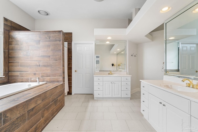 bathroom featuring two vanities, a garden tub, and a sink