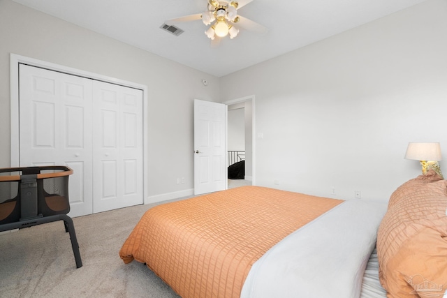 bedroom with a closet, visible vents, a ceiling fan, light carpet, and baseboards