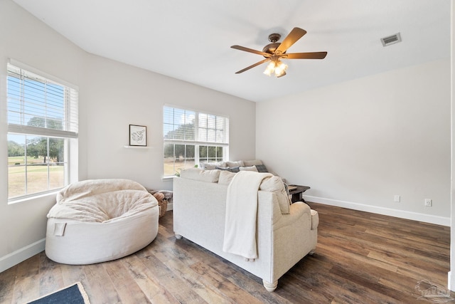 living room with dark wood finished floors, visible vents, and baseboards