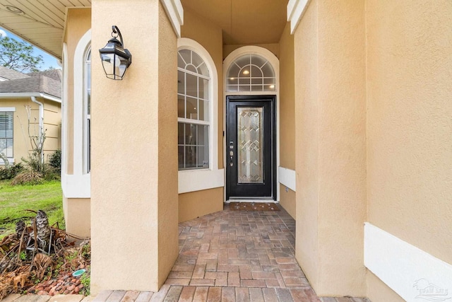 view of exterior entry featuring stucco siding