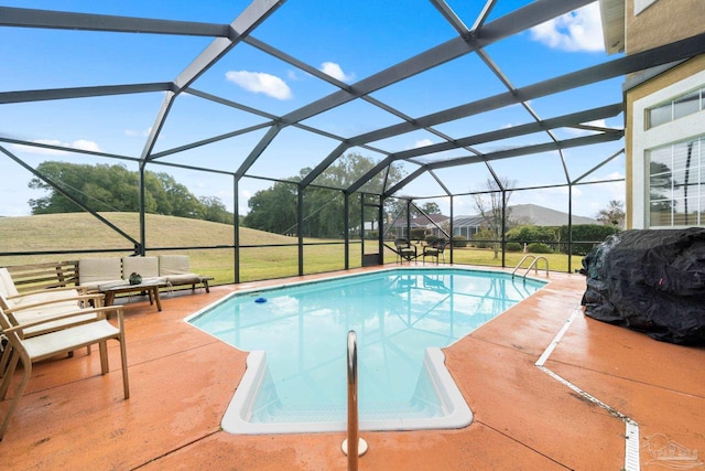 outdoor pool featuring a yard, glass enclosure, and a patio