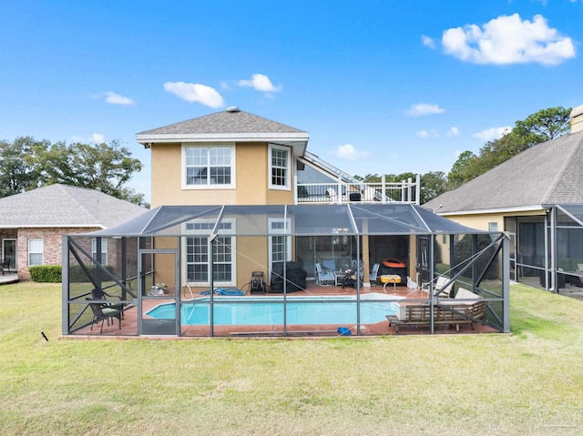 rear view of house with an outdoor pool, a lanai, and stucco siding