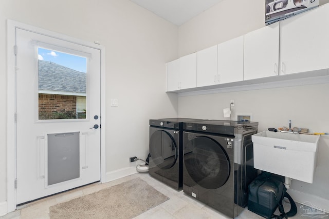 washroom with separate washer and dryer, a sink, cabinet space, and baseboards