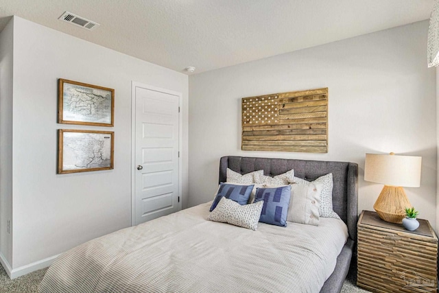 bedroom with carpet floors and a textured ceiling