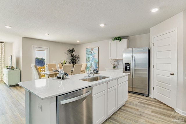 kitchen featuring a center island with sink, white cabinetry, sink, and stainless steel appliances