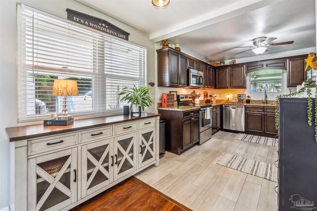 2543 Bayview Way, Pensacola, FL 32503 - kitchen featuring stainless steel appliances, light wood-style floors, dark brown cabinets, a ceiling fan, and beam ceiling