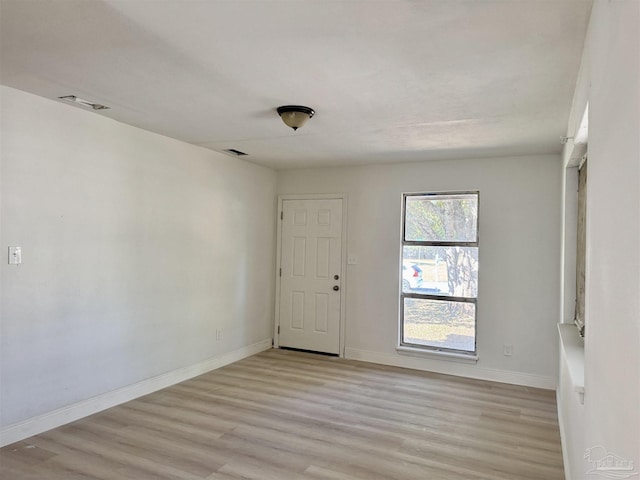 unfurnished room featuring light wood finished floors and baseboards