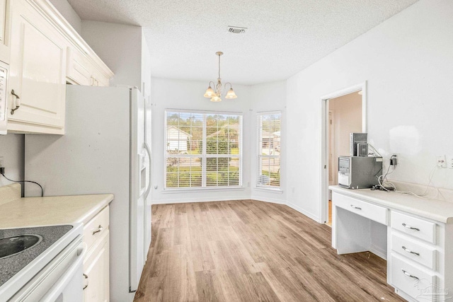 kitchen featuring a textured ceiling, pendant lighting, light hardwood / wood-style flooring, a notable chandelier, and white cabinets