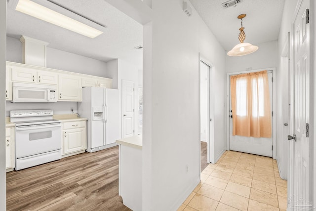 kitchen with pendant lighting, white appliances, white cabinets, light hardwood / wood-style flooring, and a textured ceiling