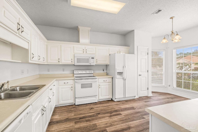 kitchen with white appliances, sink, hanging light fixtures, dark hardwood / wood-style floors, and white cabinetry