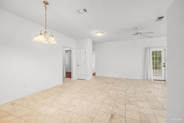 empty room featuring ceiling fan with notable chandelier