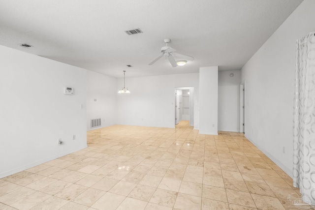 empty room with ceiling fan with notable chandelier