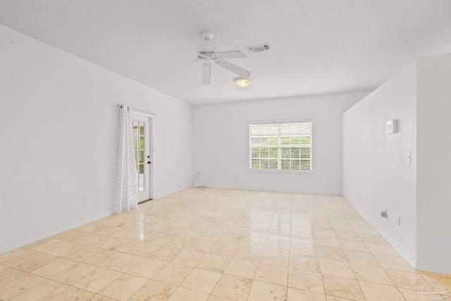 unfurnished room with a textured ceiling, ceiling fan, and light tile patterned flooring