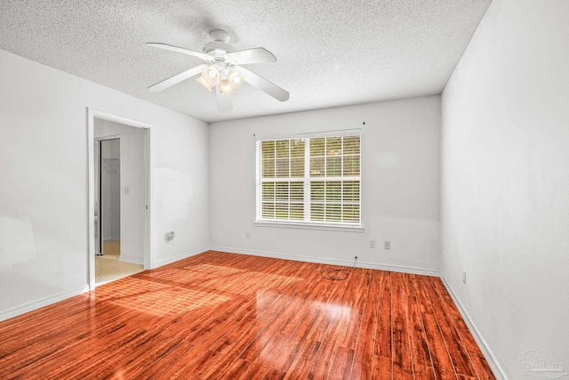 empty room featuring a textured ceiling, light wood-type flooring, and ceiling fan