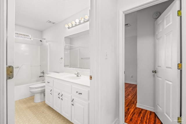 full bathroom with bathtub / shower combination, vanity, a textured ceiling, wood-type flooring, and toilet