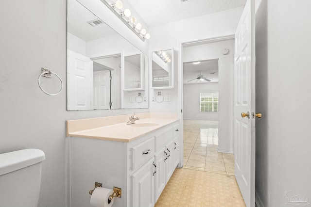 bathroom featuring vanity, toilet, and a textured ceiling