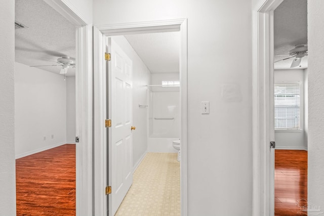 hallway featuring a textured ceiling and light wood-type flooring