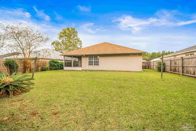 rear view of property featuring a sunroom and a yard