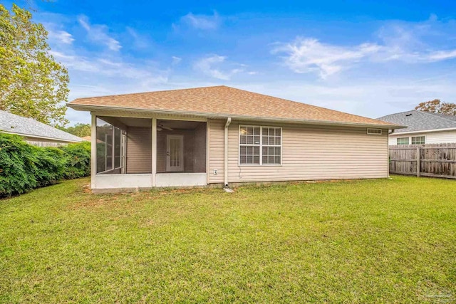 rear view of property with a sunroom and a lawn