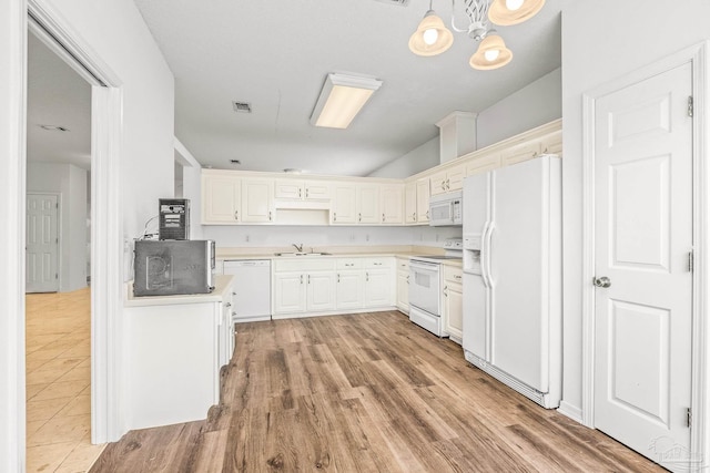 kitchen with white appliances, sink, light hardwood / wood-style flooring, white cabinetry, and hanging light fixtures