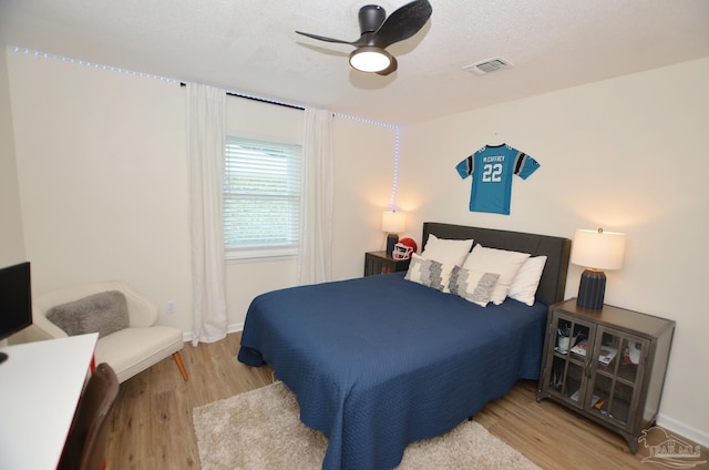 bedroom featuring a textured ceiling, light wood-type flooring, and ceiling fan