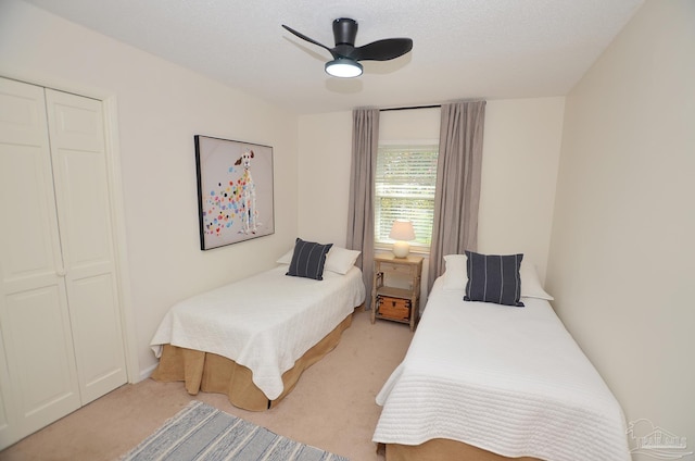 carpeted bedroom featuring a textured ceiling, a closet, and ceiling fan