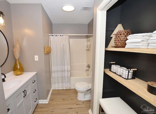 full bathroom featuring shower / bath combo, vanity, a textured ceiling, hardwood / wood-style flooring, and toilet