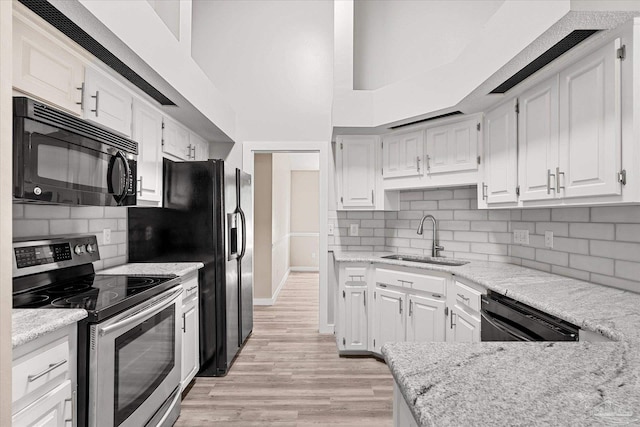 kitchen with white cabinetry, sink, light stone countertops, backsplash, and appliances with stainless steel finishes