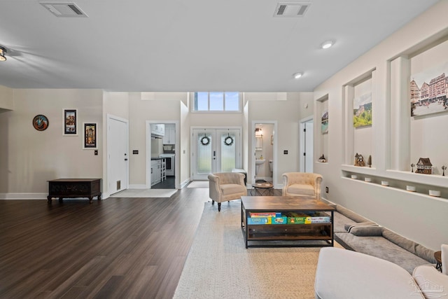 living room featuring dark wood-style floors, baseboards, visible vents, and french doors