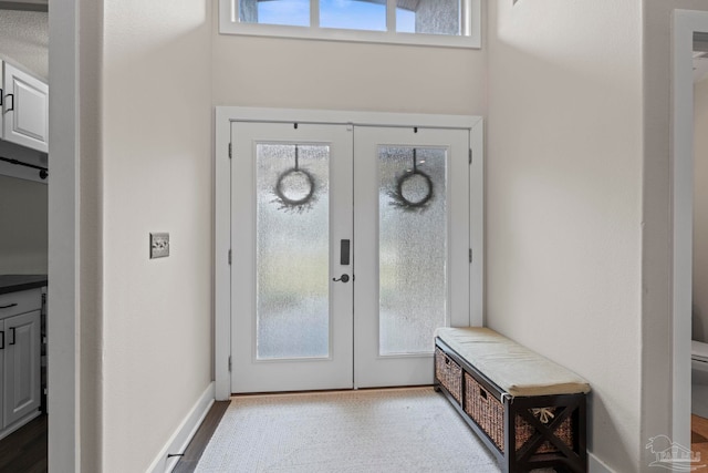 foyer entrance with french doors and baseboards