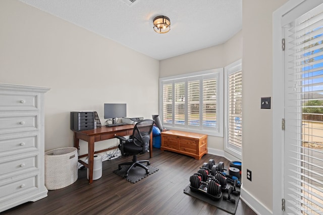 home office featuring a wealth of natural light, a textured ceiling, baseboards, and dark wood-type flooring