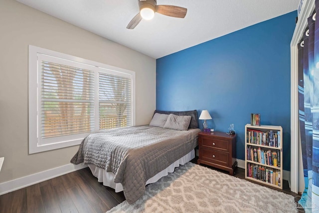 bedroom featuring ceiling fan, baseboards, and wood finished floors