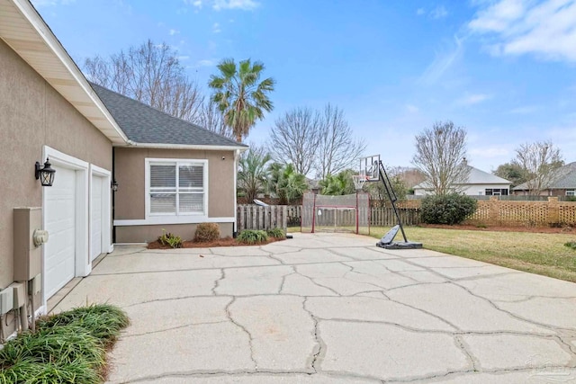 view of patio / terrace with driveway, a garage, and fence