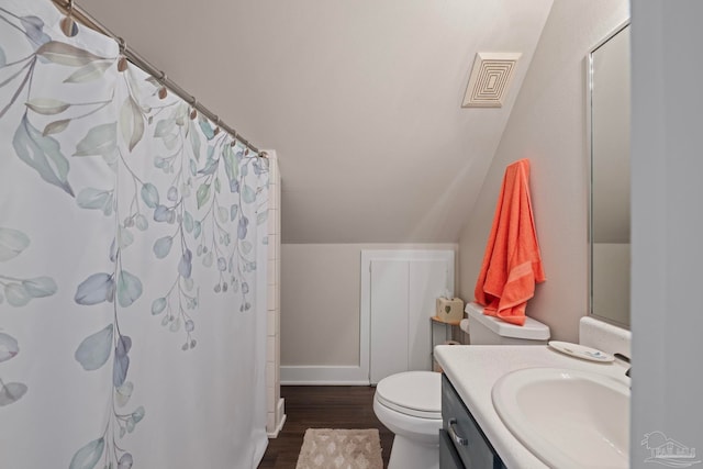 full bath with toilet, wood finished floors, vanity, visible vents, and vaulted ceiling