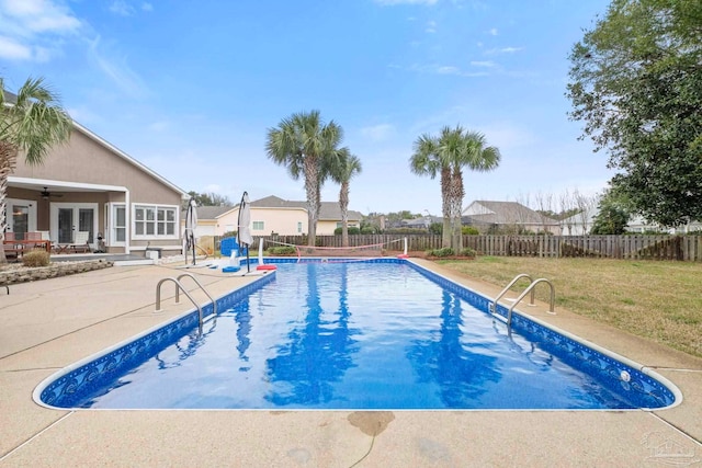 view of pool featuring french doors, a lawn, a patio area, and a fenced backyard