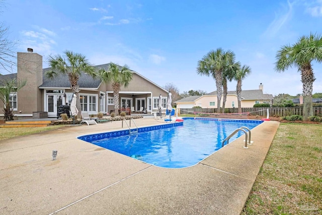 view of swimming pool featuring a fenced in pool, fence, a patio, and french doors