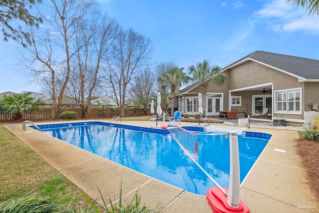 view of swimming pool with french doors, a patio area, fence, and a fenced in pool