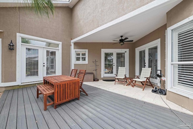 wooden deck with ceiling fan, french doors, and outdoor dining area