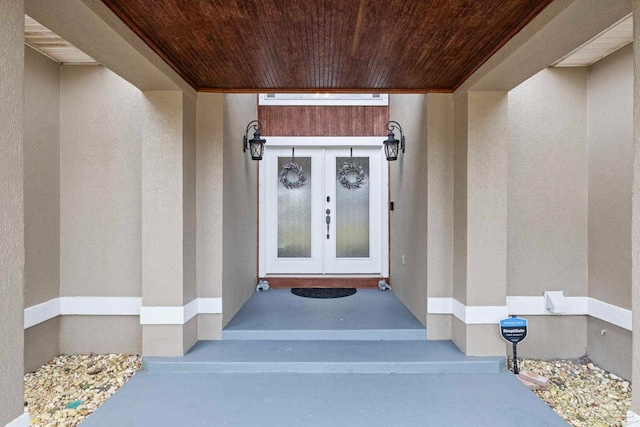 view of exterior entry with stucco siding and french doors