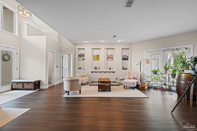 living area with dark wood-style flooring and visible vents