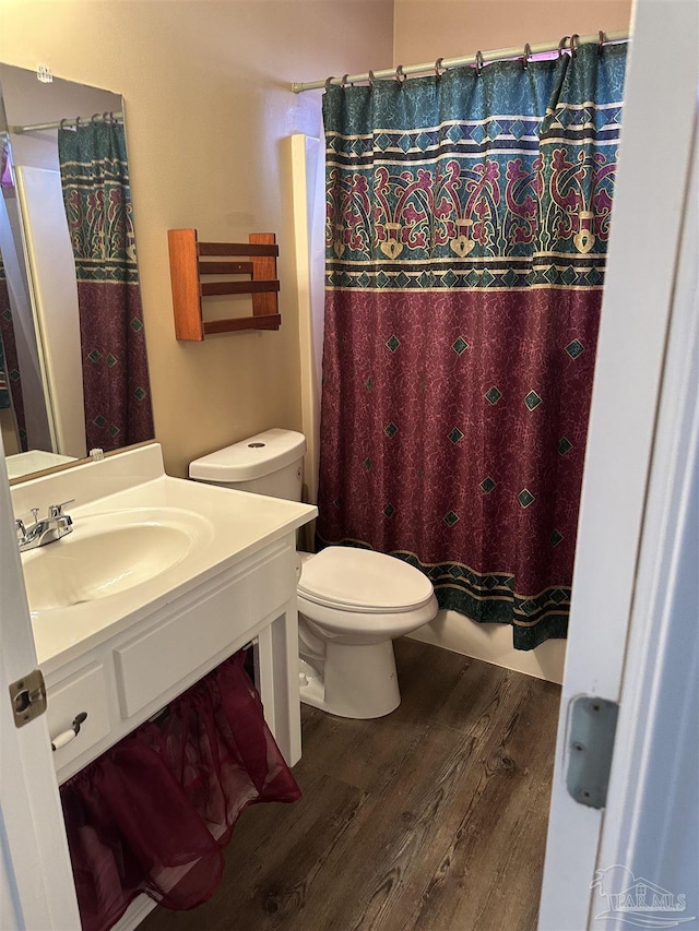 bathroom with vanity, shower / tub combo, wood finished floors, and toilet