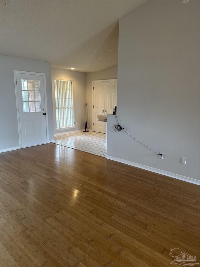 unfurnished room featuring wood-type flooring and baseboards