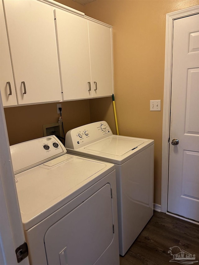 laundry area with dark wood-type flooring, washer and dryer, and cabinet space