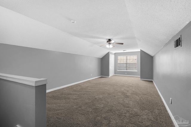 bonus room with ceiling fan, carpet flooring, vaulted ceiling, and a textured ceiling