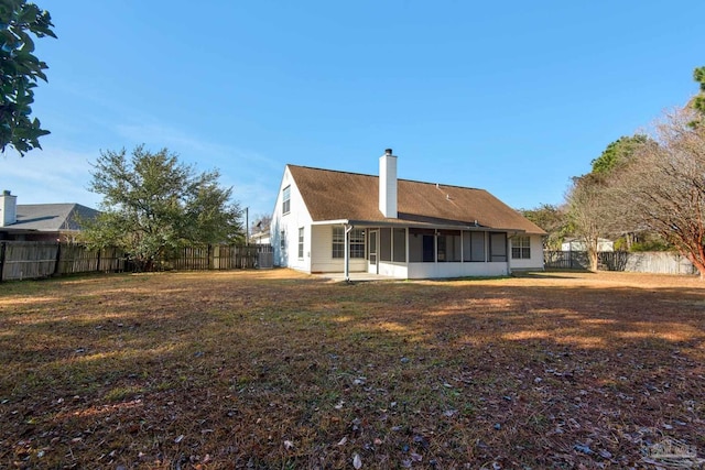 back of property with a yard and a sunroom