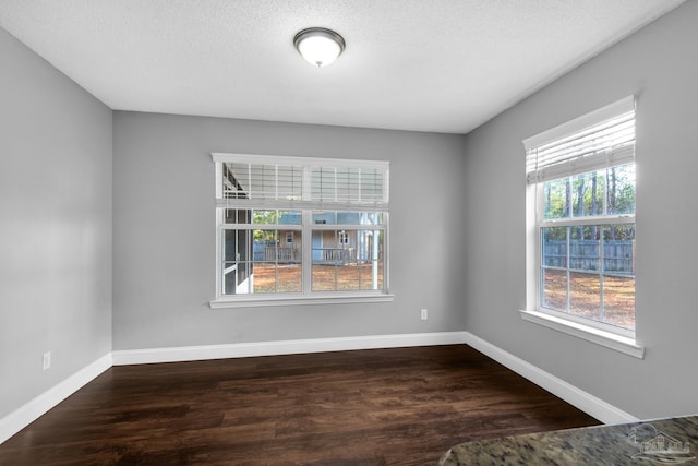 empty room featuring dark wood-type flooring and a textured ceiling