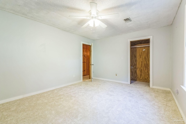 unfurnished bedroom featuring carpet, ceiling fan, and a textured ceiling